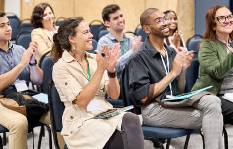 Multiracial group of businesspeople applauding during a presentation at a conference